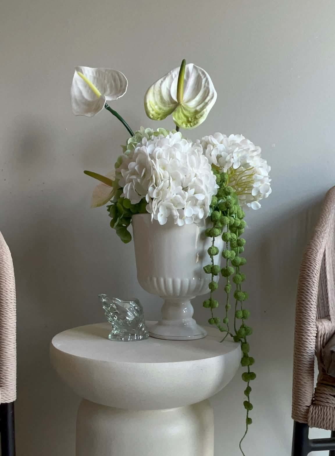 Hvite blomster og grønne ranker i lyse vaser